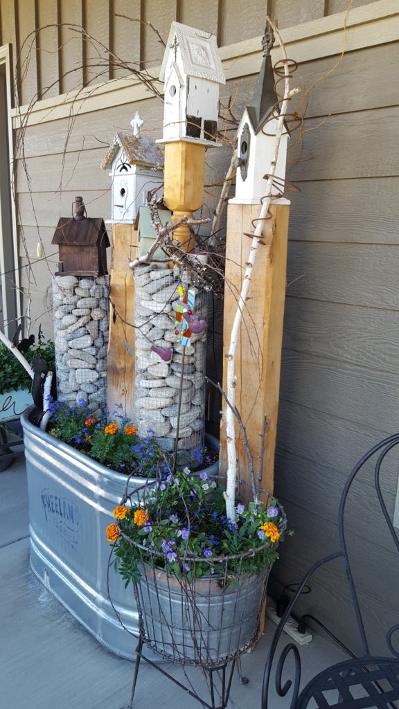 Galvanized water trough, baskets of river rock, birdhouses and bed springs