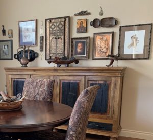 art and artifacts hanging above hutch in dining room